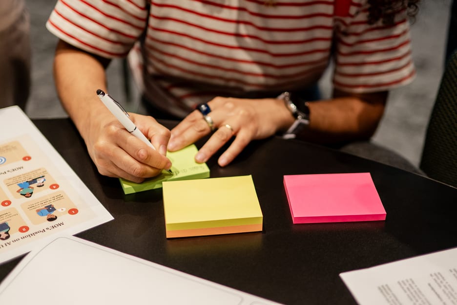 Mãos escrevendo orientações de carreira em post-its