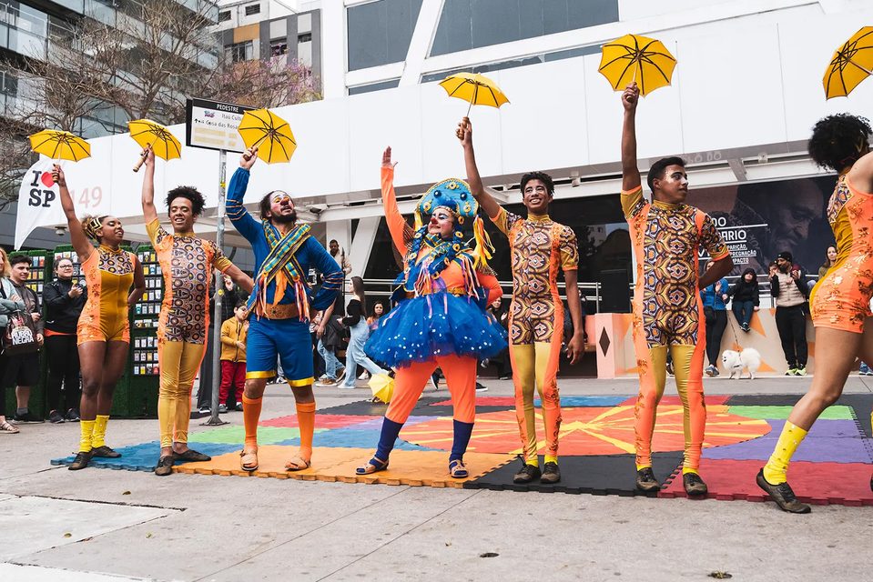 Artistas de rua com guarda-chuvas amarelos